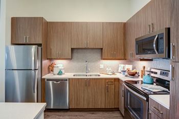 Dark finish package: dark brown cabinets, cream quartz countertops, hexagon mosaic backsplash, espresso wood-like flooring in living spaces and grey porcelain tile bathroom floors